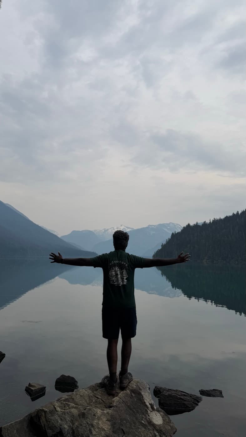 Standing on a rock at the edge of a mountain lake